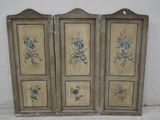 three antique painted wooden doors with flowers on them in a room