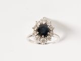 un gros plan d'une bague sertie d'un diamant noir et blanc sur une surface blanche