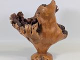 a small wooden sculpture of a bird on a stand