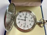 une montre de poche en argent dans une boîte bleue