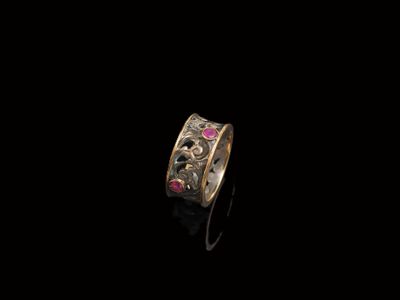 un gros plan d'une bague en or sertie de pierres roses