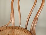 a wicker chair with a wooden seat and back rest