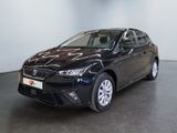 Une voiture noire est garée dans une pièce au sol noir.