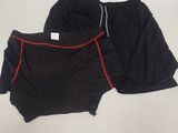 deux paires de shorts noirs et rouges posées sur un lit