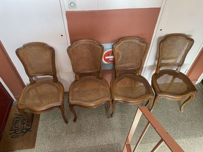 quatre chaises sont alignées en rang dans une pièce