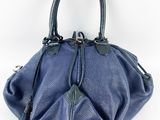 un sac à main bleu avec un pompon suspendu à la poignée