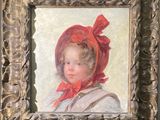 portrait d'une jeune fille coiffée d'un bonnet rouge, dans un cadre doré