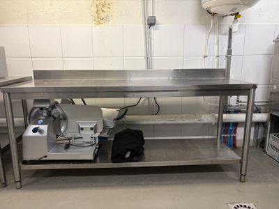 une grande table en acier inoxydable sur laquelle est posée une machine