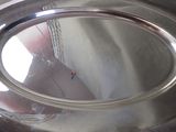 a reflection of a person in a mirror on a silver plate
