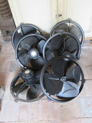 une pile de pales de ventilateur posée sur le sol à côté d'une porte