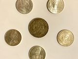 six different coins are arranged in a circle on a white surface