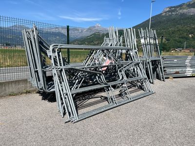 un tas de chaises en métal posées au bord de la route