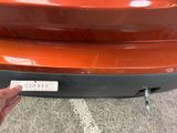 a close up of a person ' s hand holding a sticker on the bumper of a car