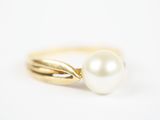 un gros plan d'une bague en perle sur fond blanc
