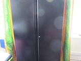 a black cabinet in the corner of a room next to a window