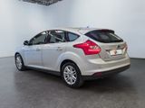 the back end of a silver car in a white room
