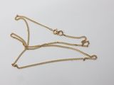 un collier en or muni d'une chaîne sur laquelle sont fixés deux anneaux