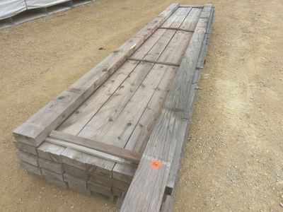 un long banc en bois posé au milieu d'un champ de terre battue