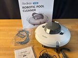 Le robot nettoyeur de piscine est posé sur la table, à côté de la boîte.