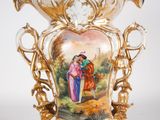 a gold vase with a picture of a man and a woman on it
