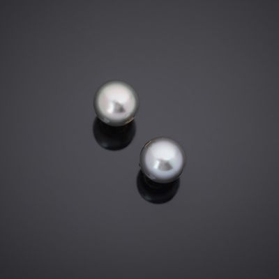 a pair of white pearls on a black surface
