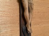 une statue de Jésus sur une croix accrochée à un mur
