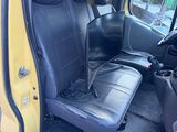 a yellow van with two black seats in the back of it
