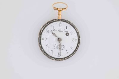 a gold and silver pocket watch on a white surface