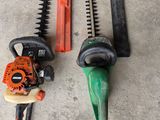 two chainsaws and a hedger on the ground