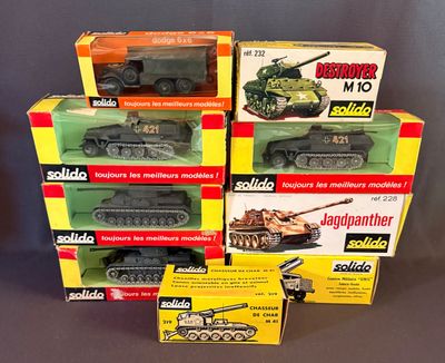 six modèles réduits de véhicules militaires dans leurs boîtes, posés sur une table
