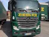 un camion vert garé sur un parking