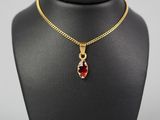 un collier plaqué or avec un pendentif en pierre rouge sur un mannequin noir