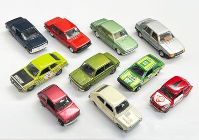 plusieurs petites voitures sont alignées sur une surface blanche
