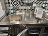 a sink in a kitchen with a lot of dishes on the counter