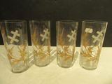 four glasses with crosses on them are lined up on a table