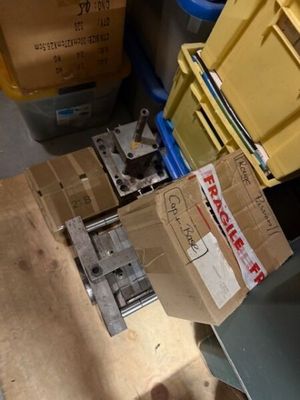 une pile de cartons posée par terre à côté d'une poubelle