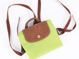 a small green purse with a brown handle on a white background