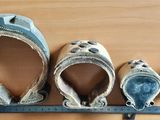 four pairs of shoes on a shelf with a ruler