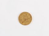 a close up of a gold coin on a white surface