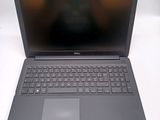 the dell laptop is open on a white surface