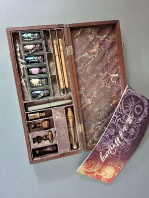 une boîte en bois contenant un stylo et quelques autres objets