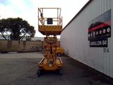 a yellow lift truck parked in front of a building