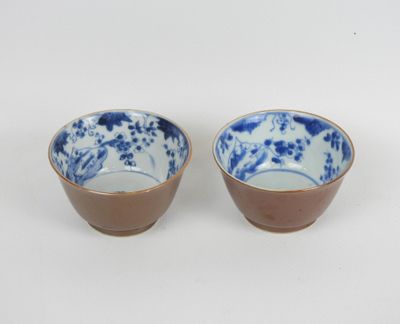 une paire de bols en porcelaine bleue et blanche posés sur un fond blanc