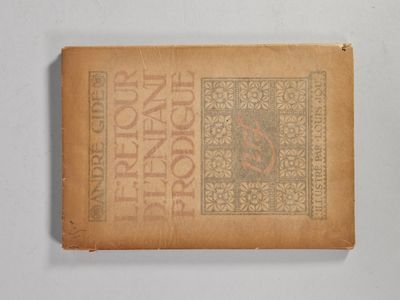 un vieux livre posé sur une table à côté d'un mur blanc