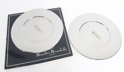 two white plates sitting on top of a black and white plate