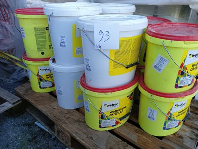 plusieurs seaux de peinture posés sur une palette en bois