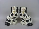 pair of black and white dog figurines with chain around their necks