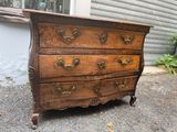 une commode marron posée devant une maison