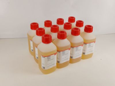 six bouteilles de liquide posées sur une surface blanche