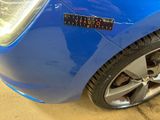 a close up of a blue car with a sticker on it